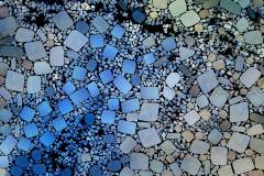 Farbiges Mosaik,  bestehend aus vielen kleinen, unregelmäßig geformten Steinchen.