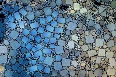 Farbiges Mosaik,  bestehend aus vielen kleinen, unregelmäßig geformten Steinchen.