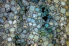 Farbiges Mosaik,  bestehend aus vielen kleinen, unregelmäßig geformten Steinchen.